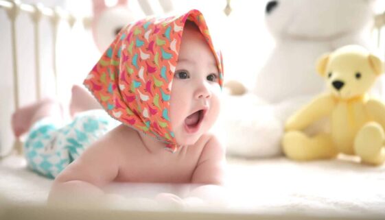 toddler wearing head scarf in bed